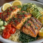- 4 salmon fillets (about 6 ounces each) - 1/4 cup extra virgin olive oil - 3 cloves garlic, minced - Juice and zest of 2 lemons - 1 teaspoon salt - 1/2 teaspoon black pepper - 1 teaspoon dried oregano - 1 cup quinoa - 2 cups vegetable or chicken broth - 1 cup cherry tomatoes, halved - 1 cucumber, diced - 1 avocado, sliced - Fresh parsley for garnish